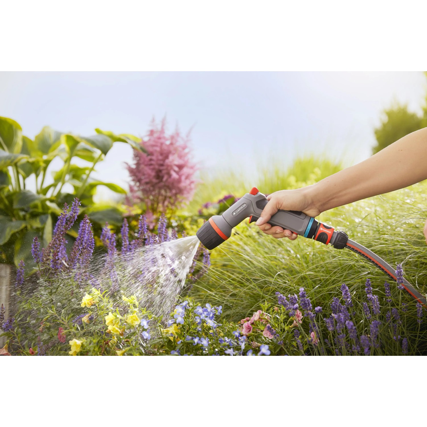 Gardena Comfort Pistola per pulizia ecoPulse™ in azione, irrigazione fiori in giardino.