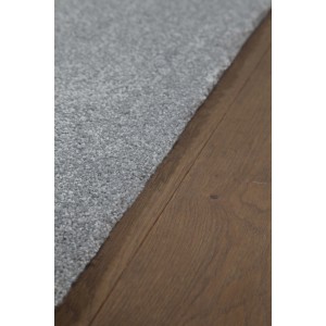 Dettaglio di un tappeto a pelo corto grigio su pavimento in legno.