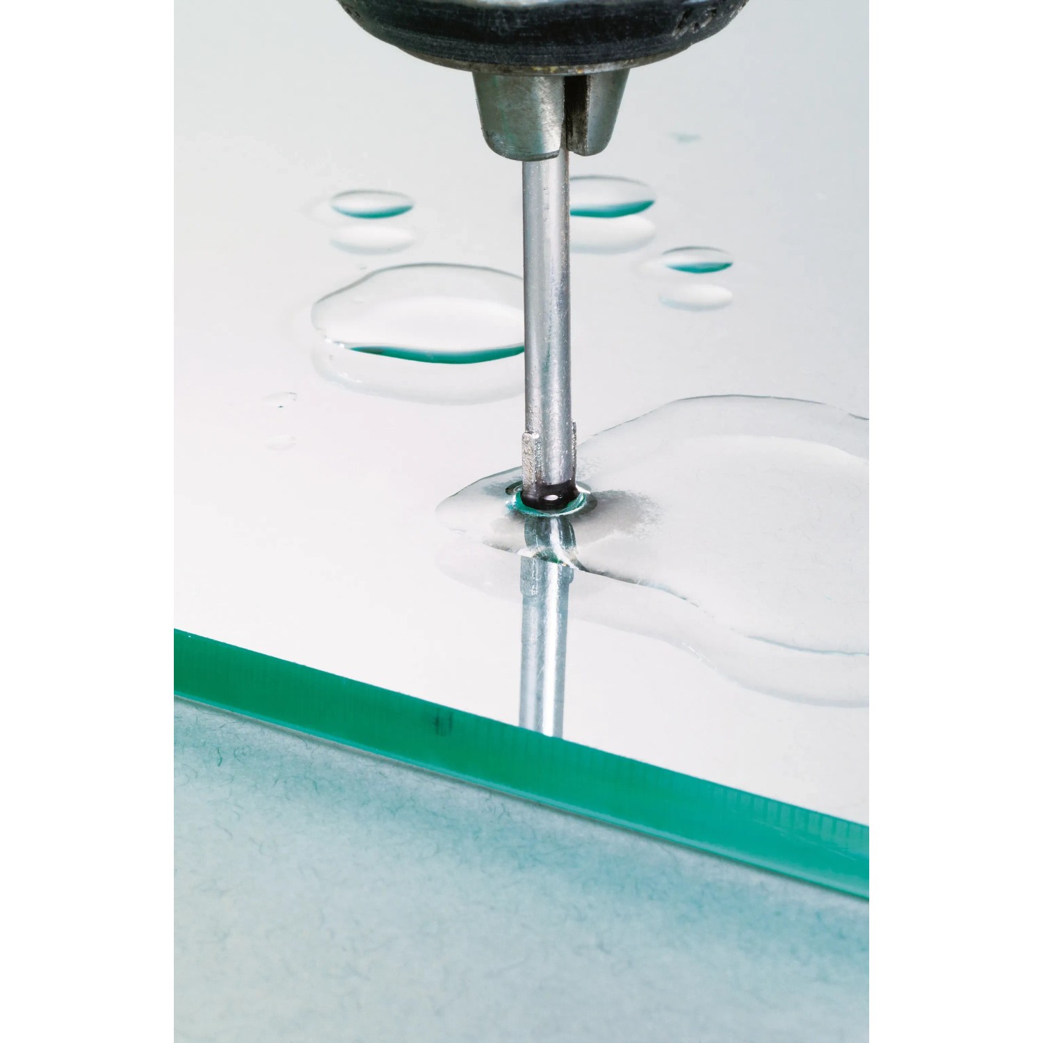 Punta per vetro LUX 4 mm che fora una lastra di vetro, raffreddata con acqua.