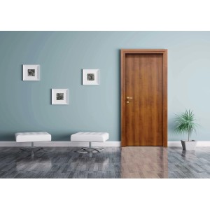 Porta interna in legno marrone in ambiente moderno con sgabelli bianchi e quadri.