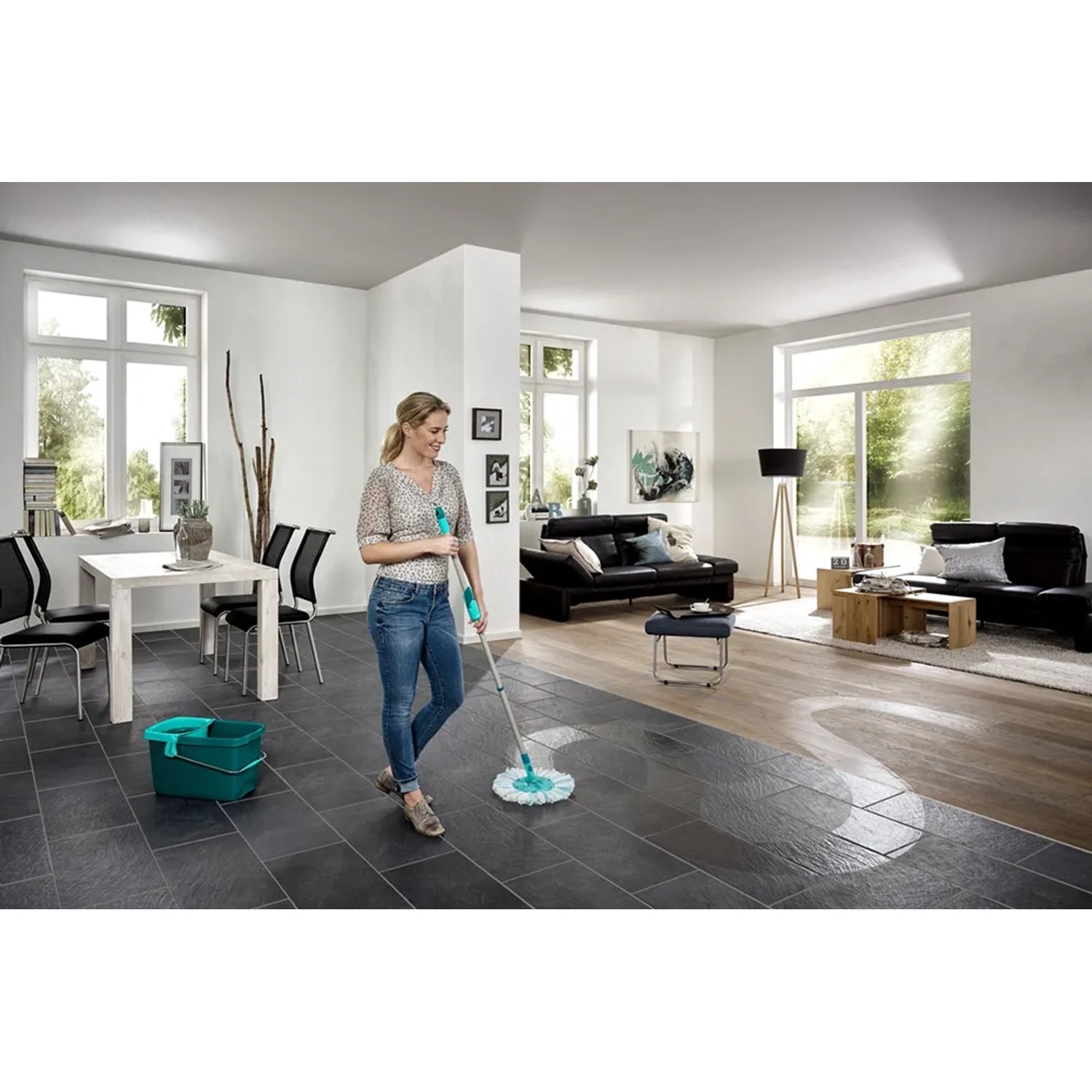 Donna lava il pavimento del soggiorno con Leifheit Clean Twist Disc Mop Ergo Micro Duo.