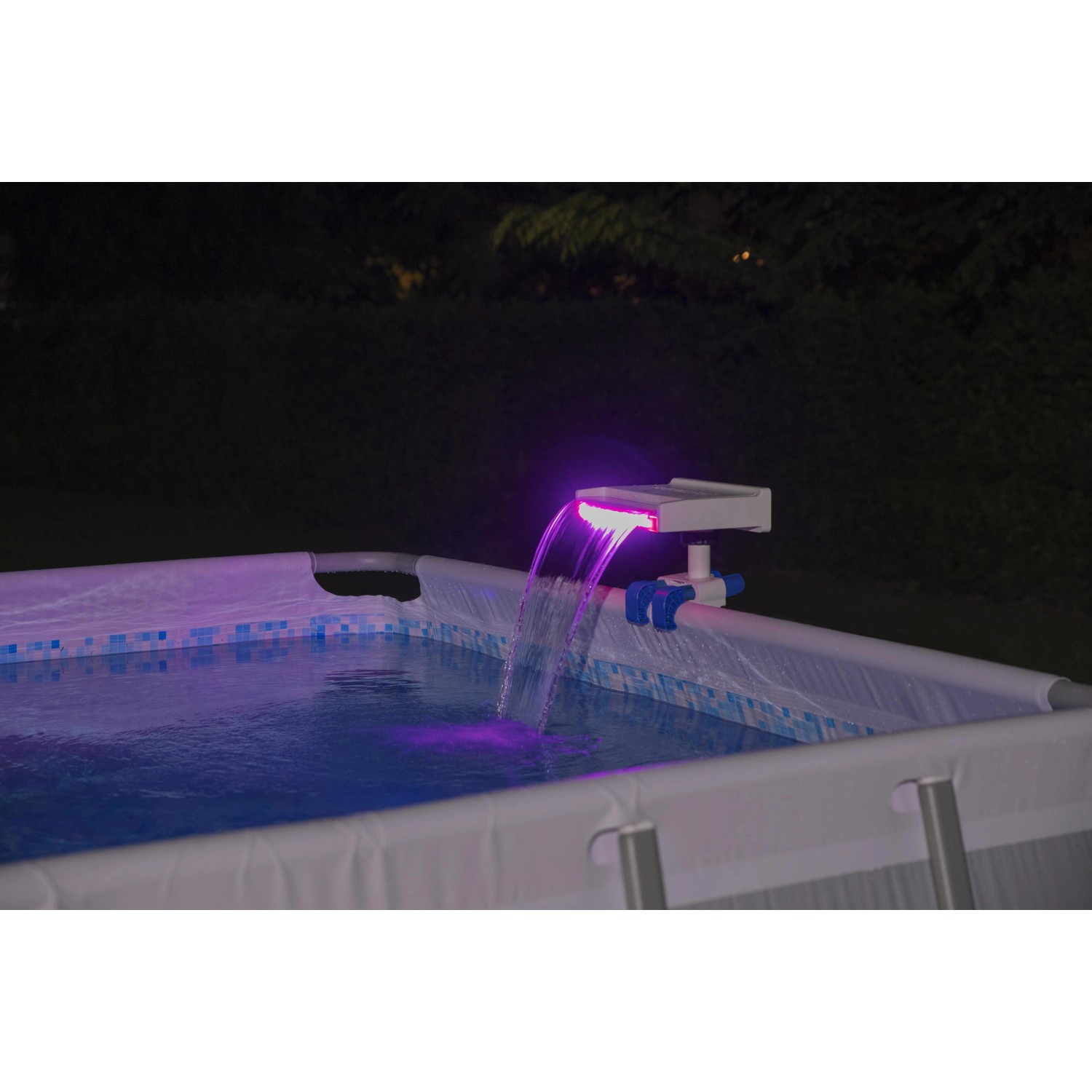Cascata per piscina Flowclear™ con luce LED sul bordo piscina, illuminata con luce viola.