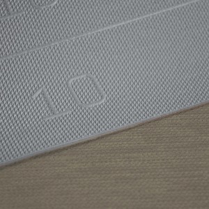 Dettaglio di un tappeto da cucina t.b.t. con motivo a rombi e il numero 10.