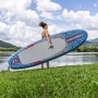 Donna che trasporta la tavola da SUP Allround Bestway Oceana (305 cm) blu al lago.