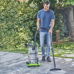Uomo che utilizza l'aspiratutto t.b.t. per pulire un patio.