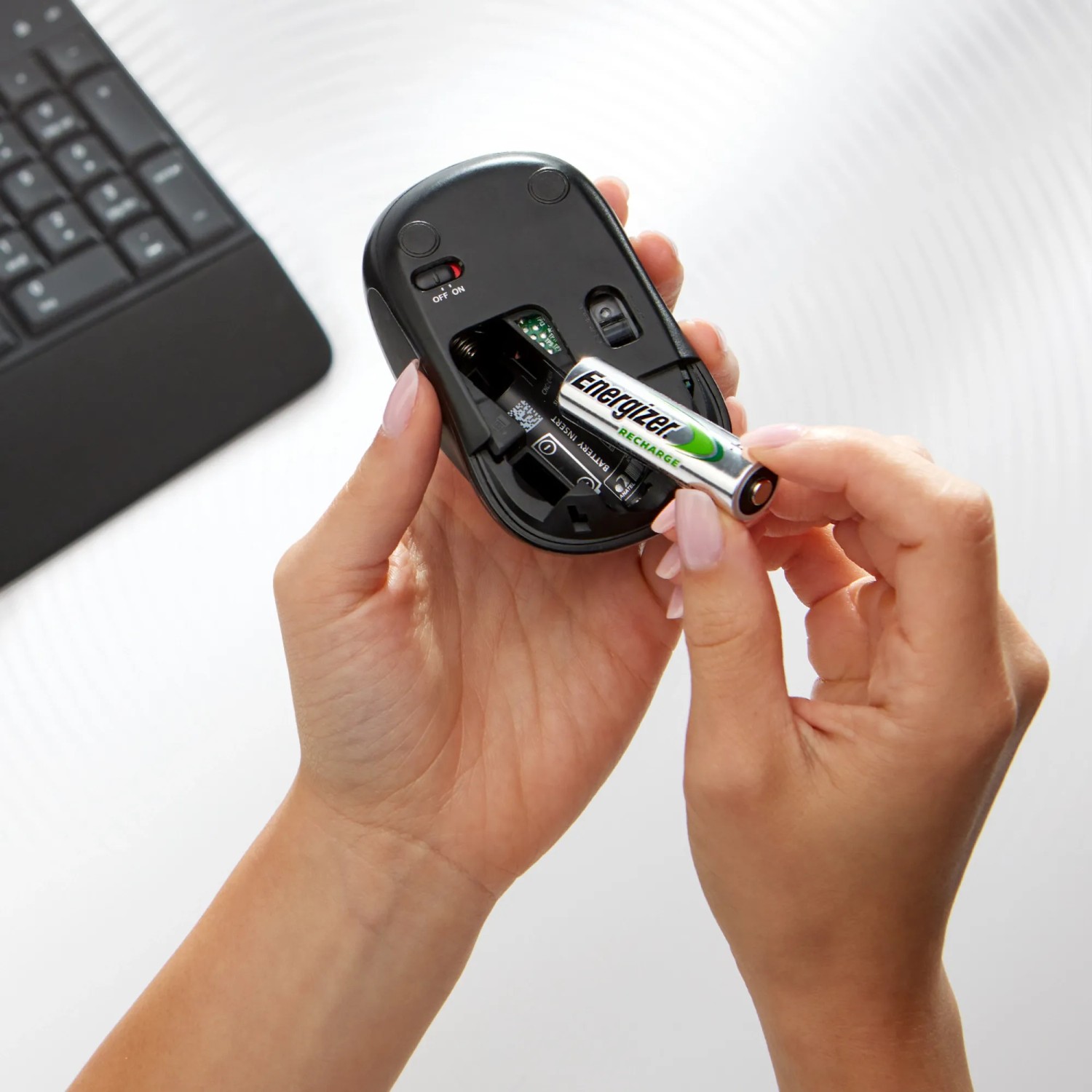 Inserimento di una batteria Energizer Power Plus AA in un mouse.