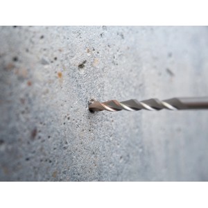 Punta per martello perforatore LUX HM SDS Plus che fora un foro in parete di cemento, diametro 5 mm.