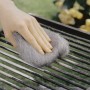 Mano pulisce la griglia con lana d'acciaio LUX grado 5. Abrasivo per la pulizia.