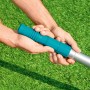 Dettaglio mani che tengono palo telescopico per piscina Bestway (360 cm), focus sull'impugnatura blu.