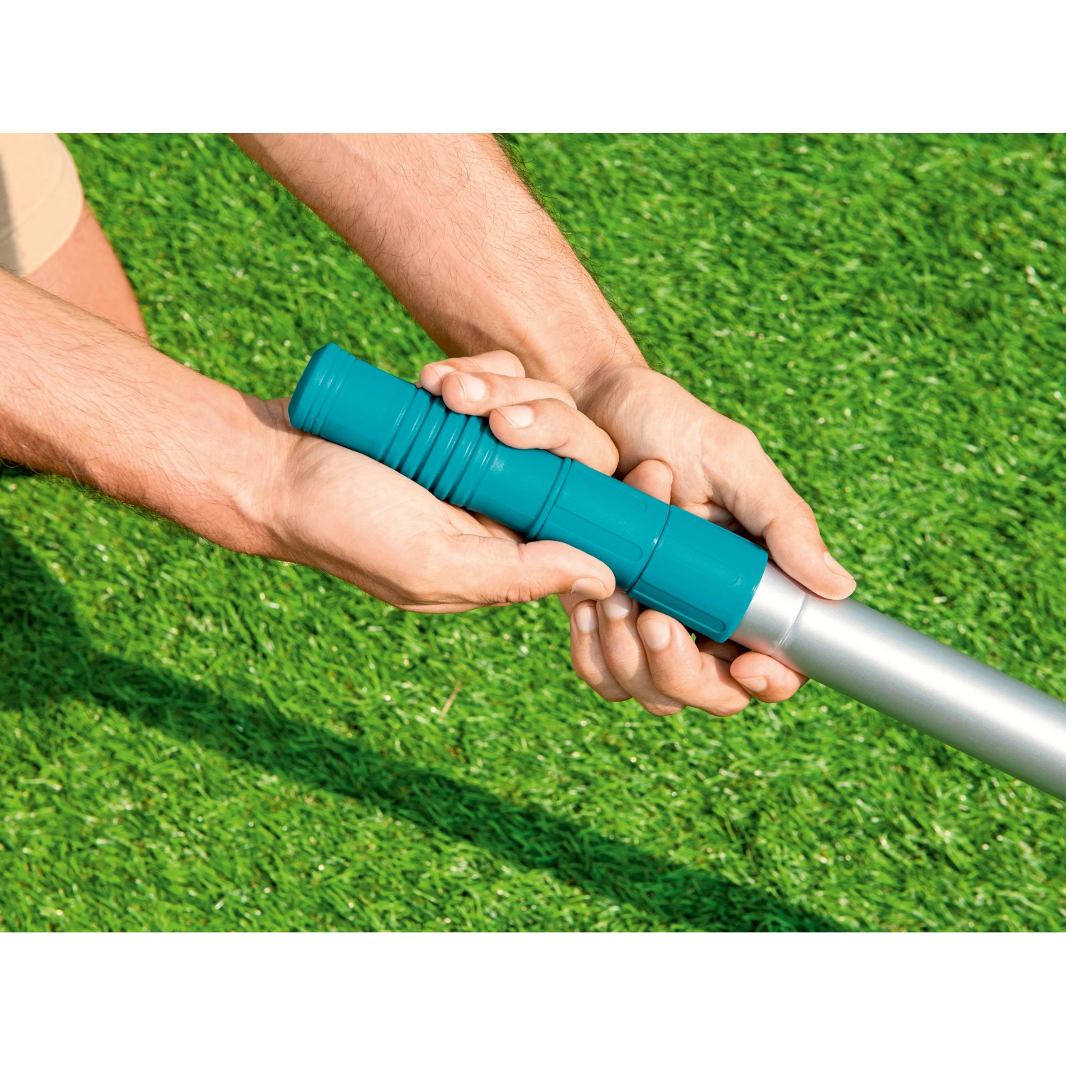 Dettaglio mani che tengono palo telescopico per piscina Bestway (360 cm), focus sull'impugnatura blu.