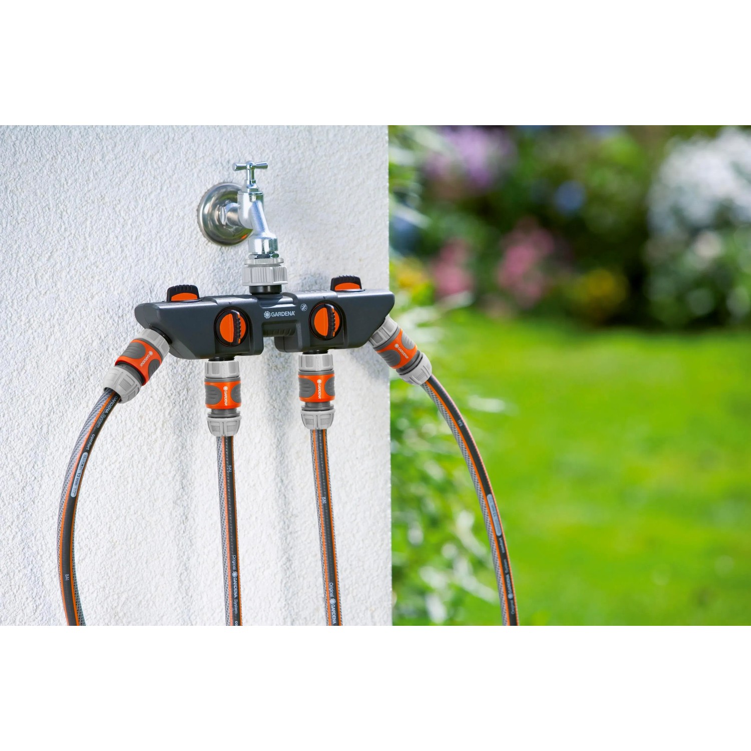 Distributore d'acqua Gardena con rubinetto e tre connessioni per irrigazione giardino.