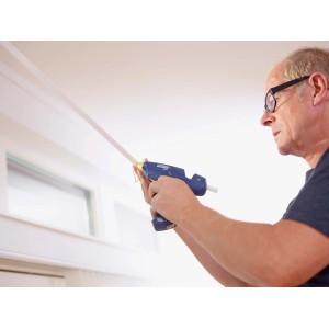 Uomo che usa una pistola per colla blu per fissare una striscia.