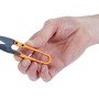 Mano che tiene piccole cesoie per fili arancioni. Strumento di precisione per tagliare i fili.