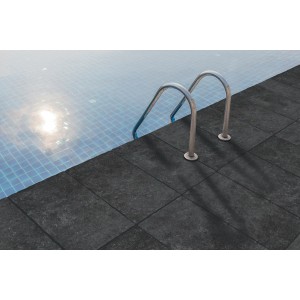 Piastrelle scure in pietra naturale a bordo piscina con scala in acciaio inox.