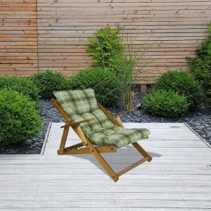 Lettino prendisole in legno con cuscino a quadri verdi in giardino.
