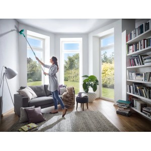 Donna pulisce l'angolo con la scopa per pareti e soffitti Leifheit Dusty con manico telescopico.
