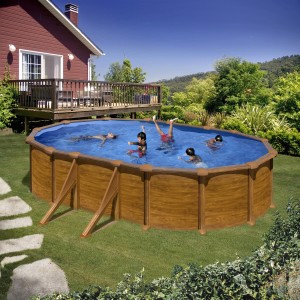 Piscina ovale Gre Mauritius effetto legno, 610x375x132 cm, con persone che nuotano in giardino.