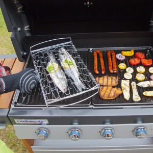 Griglia con pesce, salsicce, carne e verdure. Accessori per barbecue.