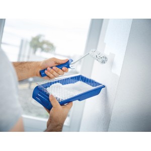 Uomo che dipinge la parete con rullo e set di dispersione LUX da 10 pezzi.