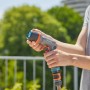 Gardena Comfort Cleaning Spray ecoPulse™ in azione: mano che tiene l'irroratrice da giardino con diversi modelli di spruzzo.