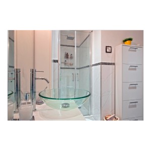 Lavabo d'appoggio in vetro trasparente in un bagno moderno.