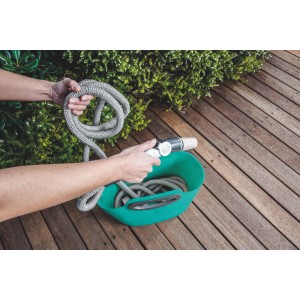 Tubo da giardino t.b.t. grigio in contenitore verde su patio in legno.