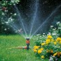 Irrigatore a cerchio Gardena Comfort Vario su picchetto irriga il prato. Irrigatore con getto d'acqua in giardino.