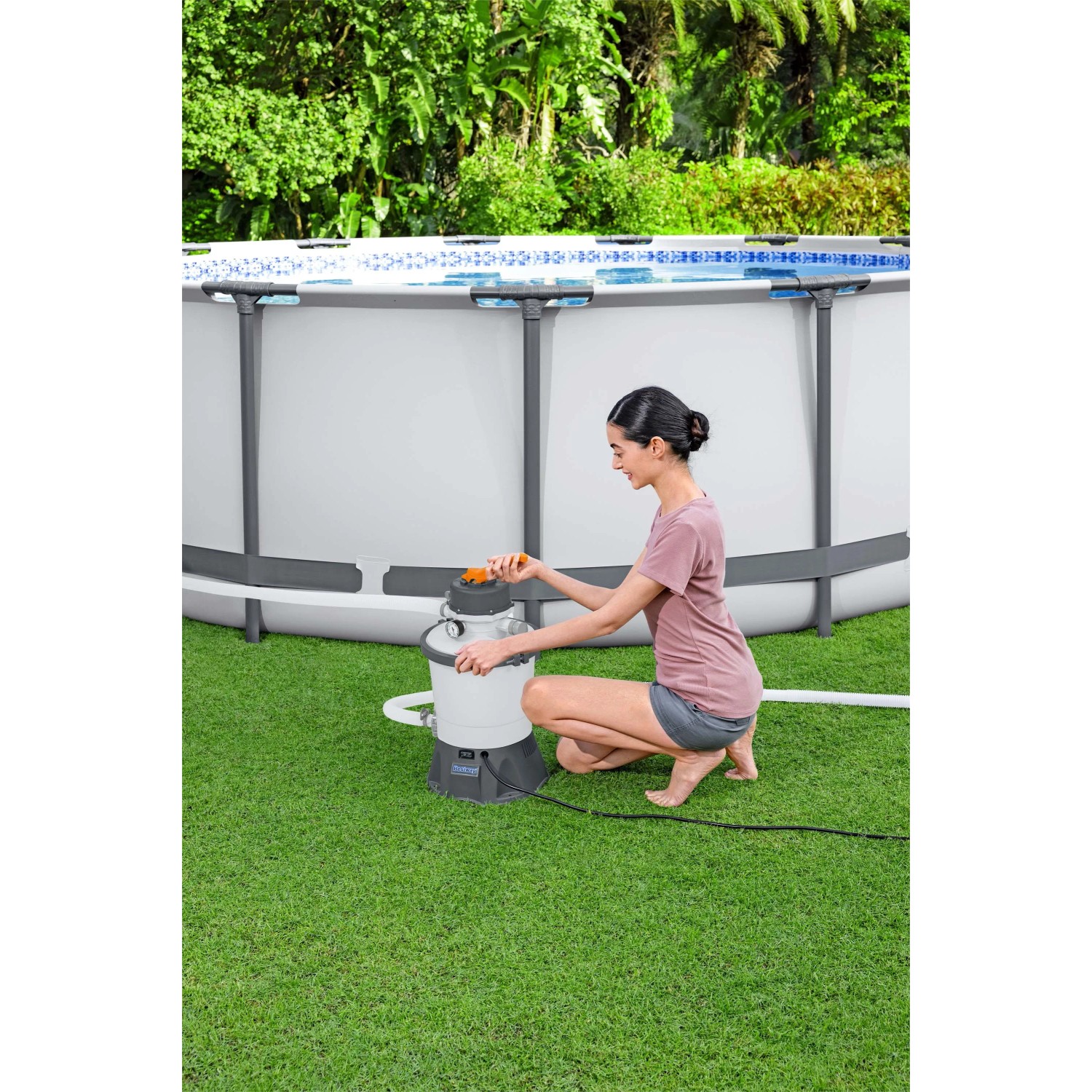 Pompa filtro a sabbia Bestway (3.028 l/h) in uso in piscina. Donna aziona il sistema di filtraggio.