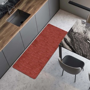 Tappeto da cucina rosso accanto a mobili da cucina grigi e tavolo da pranzo. Zerbini per cucina.