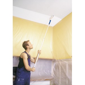 Uomo che dipinge il soffitto con rullo LUX Vestan (25 cm) su asta telescopica. Set da pittore per superfici lisce.