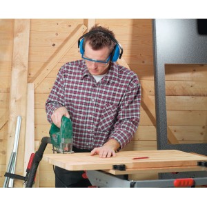 Uomo che indossa cuffie antirumore blu LUX mentre sega il legno per una protezione ottimale dell'udito.