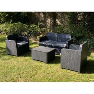 Set di mobili da giardino t.b.t. nero con divano, poltrone e tavolo su prato.