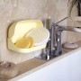 Organizzatore da bagno giallo con spugne accanto al rubinetto. Pratico Sistemazione cucina.