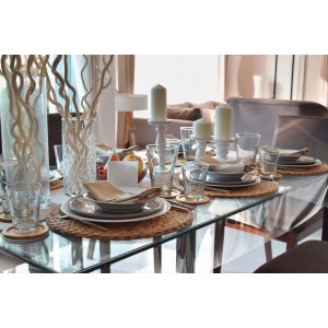 Tavola imbandita a festa con piatti, bicchieri e decorazioni. Tovaglia non visibile.