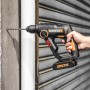 Trapano a percussione a batteria Worx WX390.1 Solo mentre fora un muro.