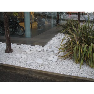 Ciottoli decorativi bianchi come bordura e decorazione in area esterna.