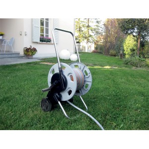 Avvolgitubo grigio con tubo su prato davanti alla casa.