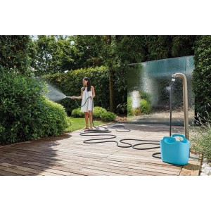 Donna che irriga il giardino con tubo per irrigazione t.b.t. e avvolgitubo.