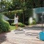 Donna che irriga il giardino con tubo per irrigazione t.b.t. e avvolgitubo.