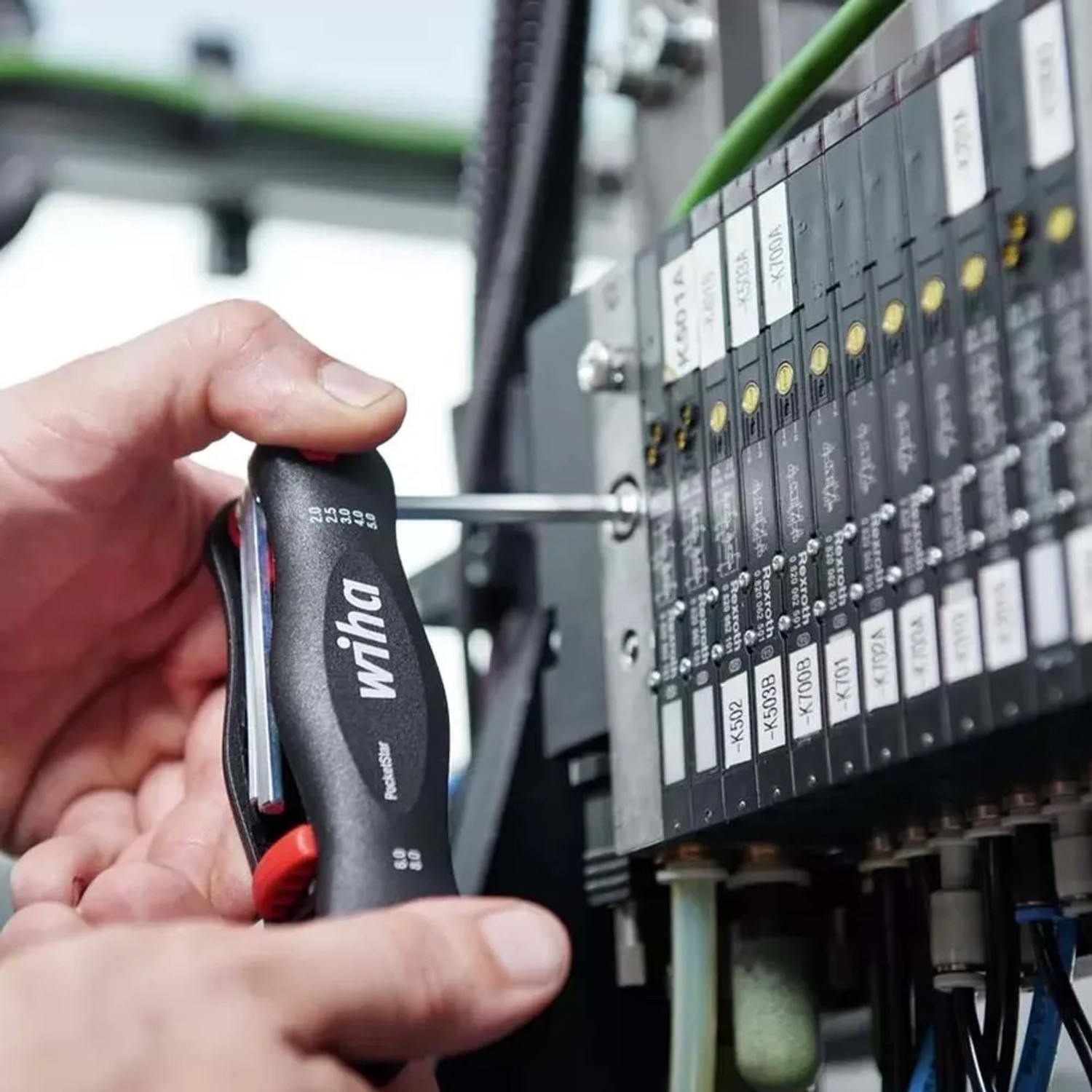 Mano usa utensile Wiha su componenti elettrici. Per installazioni elettriche e misurazioni sicure.