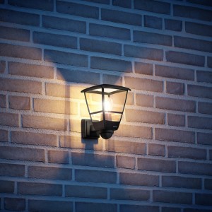 Lampada da esterno nera Steinel L 10 S con sensore su muro di mattoni.