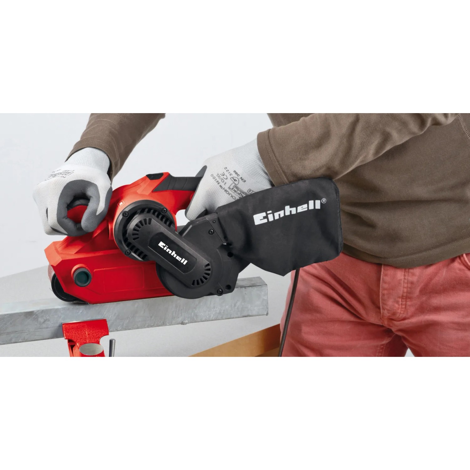 Levigatrice a nastro Einhell TC-BS 8038 in uso, rosso/nero, con aspirazione polvere.