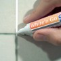 Applicazione di una penna per fughe su piastrelle per ravvivare il colore delle fughe.