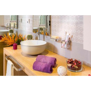 Bagno moderno con lavabo, porta asciugamani e asciugamani viola.