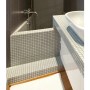Bagno con piastrelle a mosaico su vasca e lavabo.