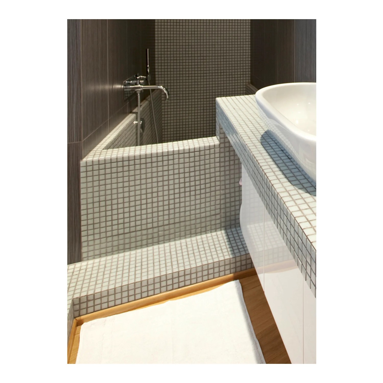 Bagno con piastrelle a mosaico su vasca e lavabo.
