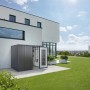 Armadio da esterno Biohort Large grigio scuro metallizzato davanti a una casa moderna. Tanto spazio per giardino e terrazza.