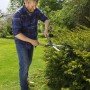 Uomo che taglia la siepe con cesoie. Attrezzi da giardinaggio per la potatura.