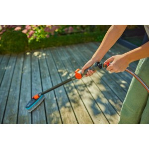 Spazzola morbida Gardena Cleansystem antracite collegata a un tubo da giardino.