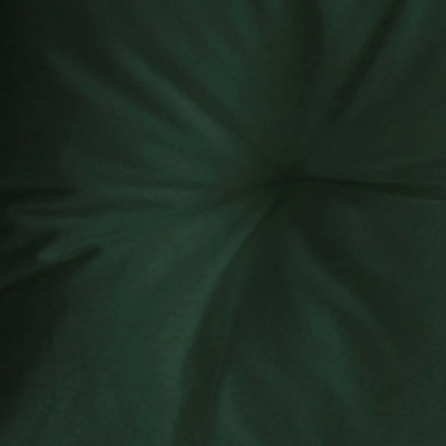 Primo piano di un cuscino/fodera per cuscino verde scuro con pieghe.